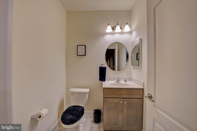 bathroom with toilet, vanity, and tile patterned flooring