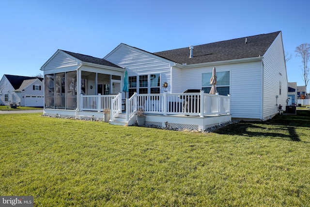 rear view of house with a wooden deck, a yard, and a sunroom