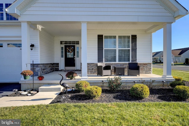 view of exterior entry with covered porch and a garage