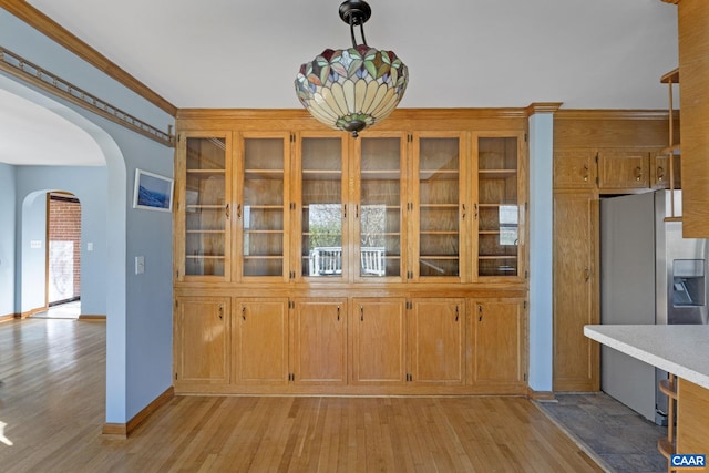 unfurnished dining area with light hardwood / wood-style floors and ornamental molding