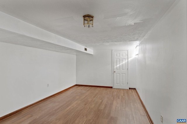 spare room with a textured ceiling and hardwood / wood-style flooring