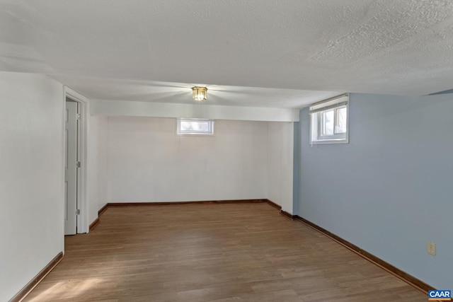 basement featuring hardwood / wood-style flooring and a textured ceiling