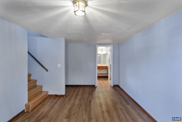 empty room with dark wood-type flooring and a textured ceiling