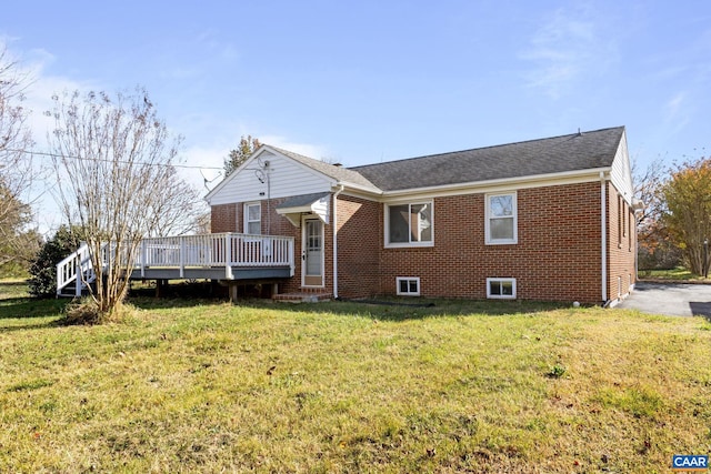 rear view of house with a lawn and a wooden deck