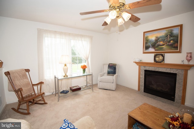 living area with ceiling fan, light carpet, and a high end fireplace