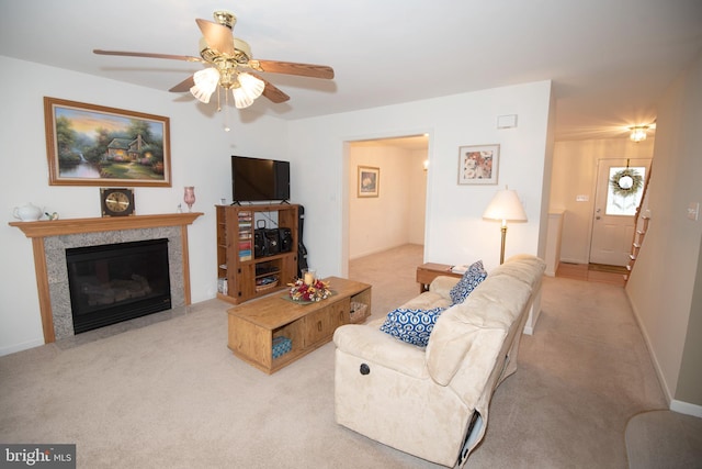 carpeted living room featuring ceiling fan and a premium fireplace