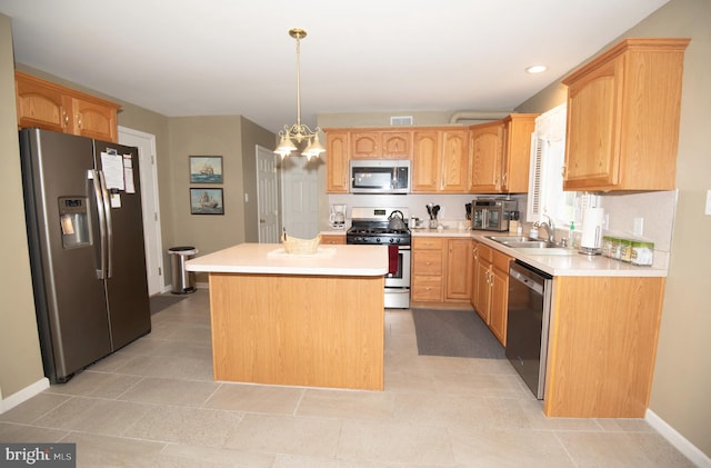 kitchen featuring sink, a notable chandelier, pendant lighting, a kitchen island, and appliances with stainless steel finishes