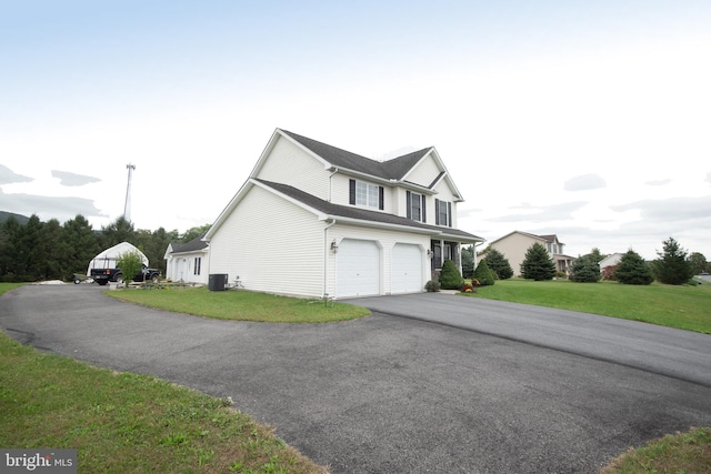 view of front of house with a front yard, a garage, and central AC unit