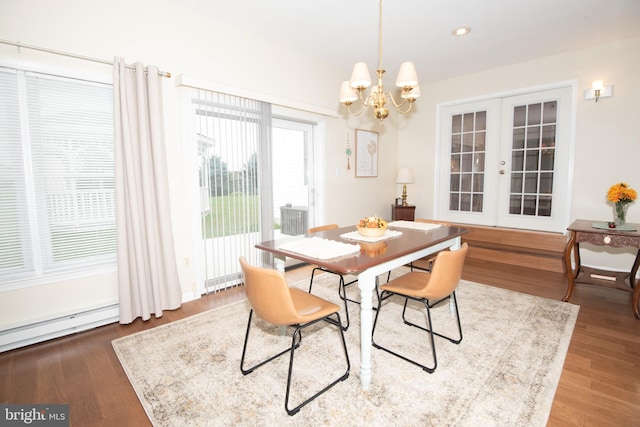 dining room featuring baseboard heating, french doors, wood-type flooring, and a notable chandelier