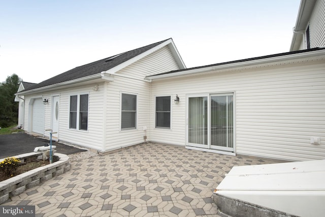 view of property exterior featuring a patio and a garage