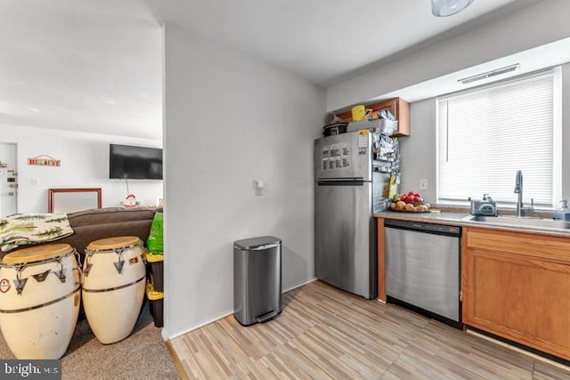 kitchen featuring sink, light hardwood / wood-style floors, and appliances with stainless steel finishes