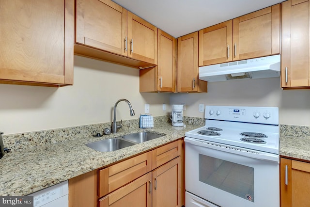 kitchen with white appliances, light stone counters, and sink