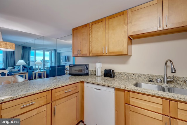 kitchen with light brown cabinetry, white dishwasher, and sink