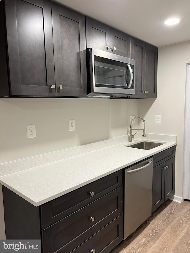 kitchen featuring sink, light hardwood / wood-style floors, and appliances with stainless steel finishes