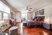 bedroom with dark hardwood / wood-style flooring and ceiling fan