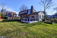 rear view of property featuring a lawn and a wooden deck