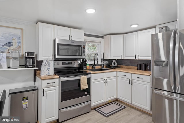 kitchen featuring white cabinetry, sink, crown molding, and appliances with stainless steel finishes