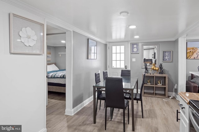 dining area featuring light hardwood / wood-style floors and ornamental molding