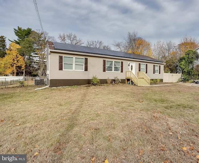 manufactured / mobile home with a front lawn and solar panels