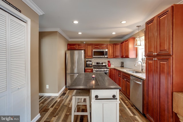 kitchen featuring appliances with stainless steel finishes, dark wood-type flooring, pendant lighting, and sink