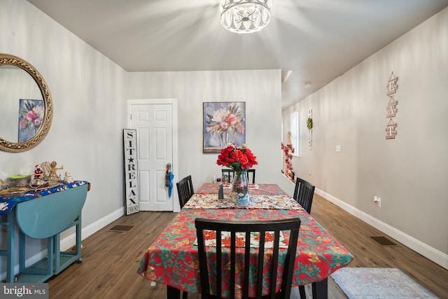 dining area with a chandelier and wood-type flooring