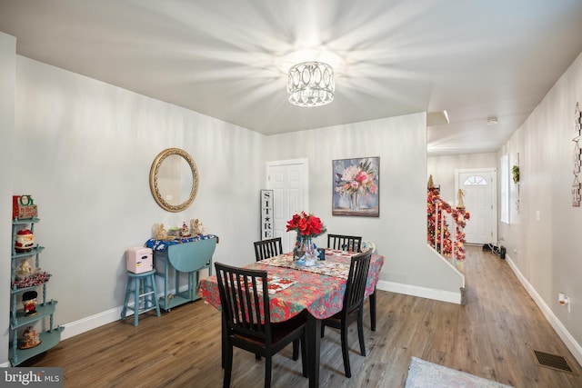 dining area with a notable chandelier and hardwood / wood-style flooring