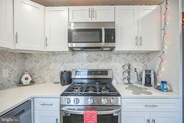 kitchen featuring light stone countertops, decorative backsplash, white cabinets, and stainless steel appliances