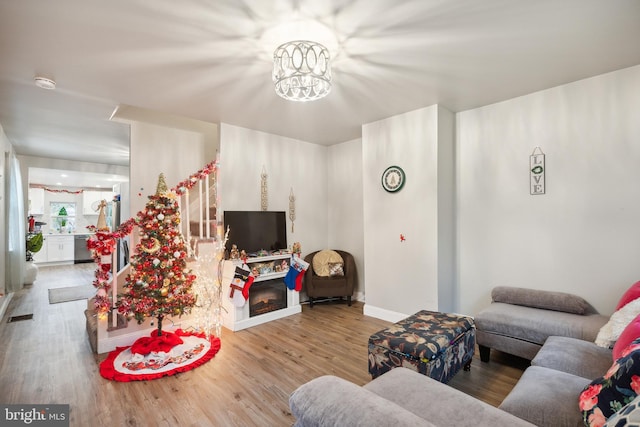 living room with light wood-type flooring and an inviting chandelier