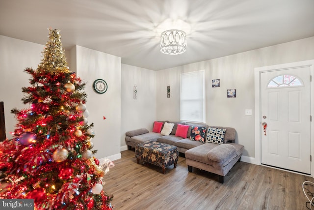 living room featuring a wealth of natural light, light hardwood / wood-style flooring, and a notable chandelier