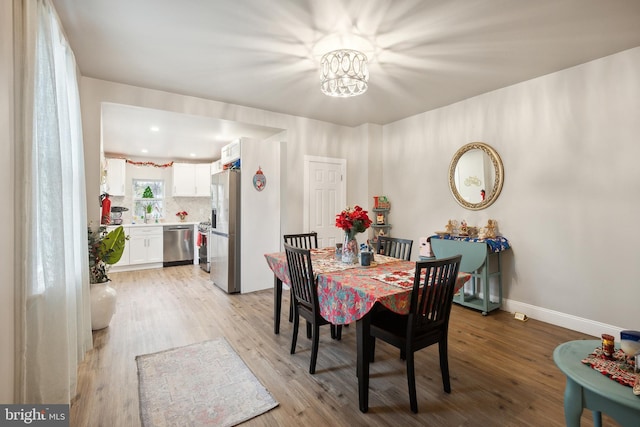 dining area featuring light hardwood / wood-style floors and a notable chandelier