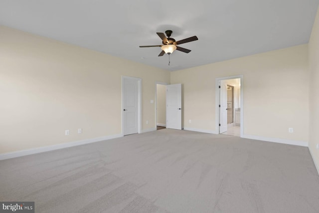 unfurnished bedroom featuring connected bathroom, light colored carpet, and ceiling fan