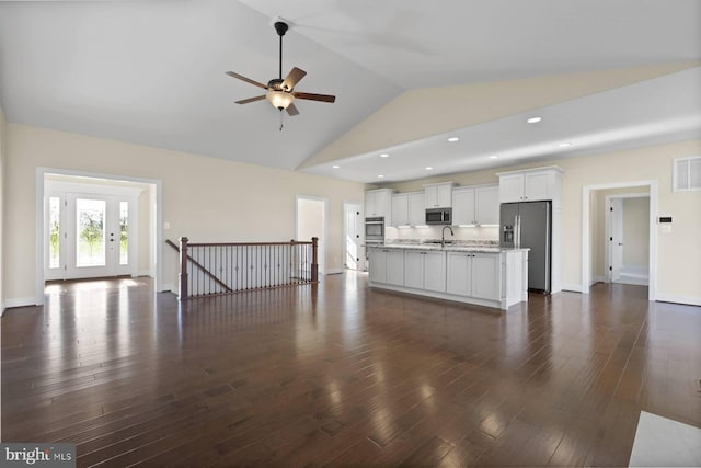 unfurnished living room with ceiling fan, sink, dark wood-type flooring, and high vaulted ceiling