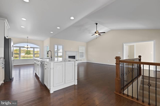 kitchen with white cabinets, appliances with stainless steel finishes, dark hardwood / wood-style flooring, and an island with sink