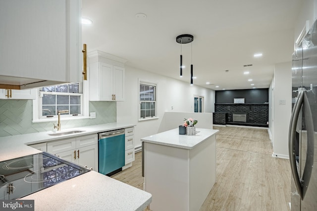 kitchen with a center island, white cabinetry, stainless steel appliances, and light hardwood / wood-style flooring