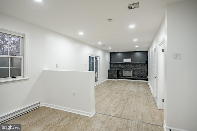 hall with light hardwood / wood-style flooring and a baseboard radiator