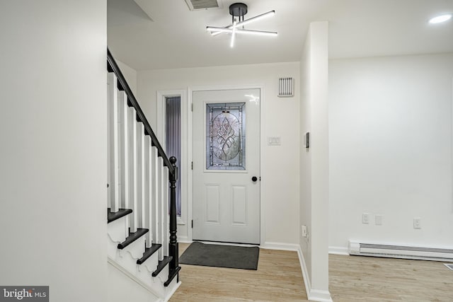 entryway with light hardwood / wood-style flooring, baseboard heating, and a notable chandelier