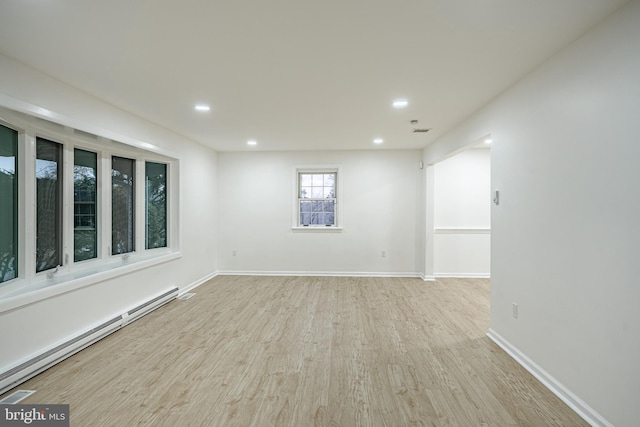 empty room with light wood-type flooring and a baseboard radiator