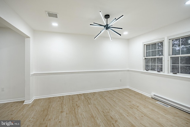 empty room featuring light hardwood / wood-style floors and baseboard heating