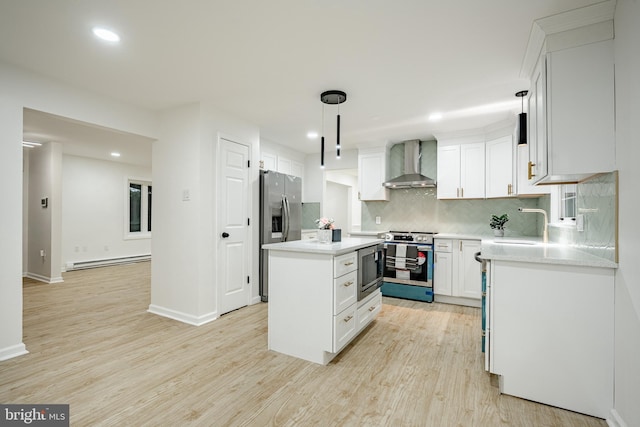 kitchen featuring stainless steel appliances, wall chimney range hood, a baseboard radiator, white cabinets, and a kitchen island