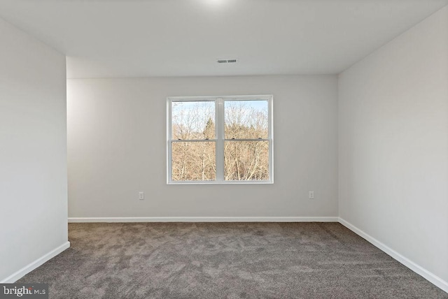 spare room featuring dark colored carpet