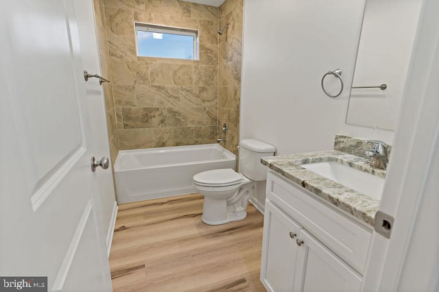 full bathroom with vanity, wood-type flooring, tiled shower / bath combo, and toilet