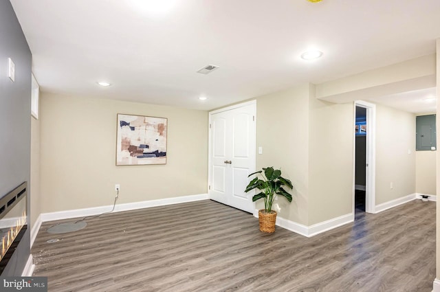 basement with hardwood / wood-style floors and electric panel