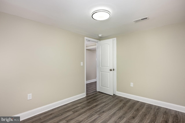 unfurnished room with dark wood-type flooring