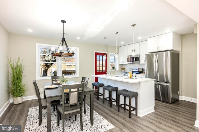 dining area featuring sink and dark wood-type flooring