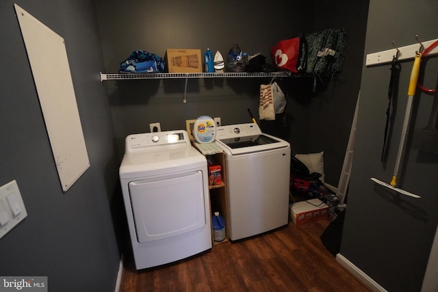 laundry area with dark hardwood / wood-style floors and washing machine and clothes dryer