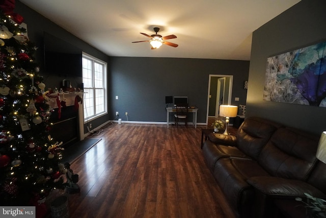 living room featuring ceiling fan and dark hardwood / wood-style flooring