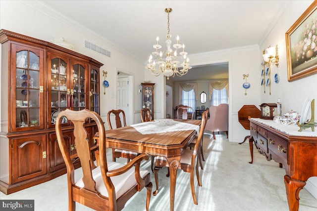 dining space with ornamental molding, light carpet, and a chandelier