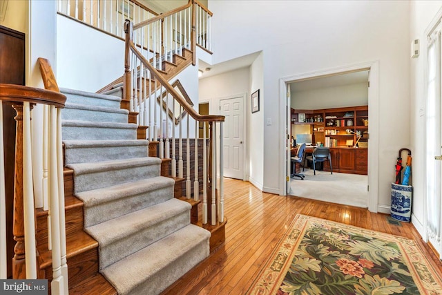 stairway featuring hardwood / wood-style floors and a high ceiling