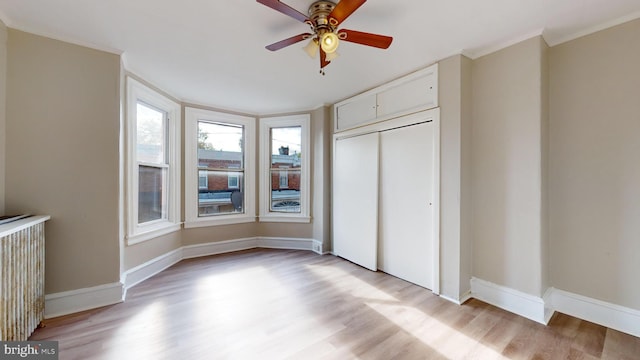 unfurnished bedroom featuring a closet, light hardwood / wood-style floors, and ceiling fan