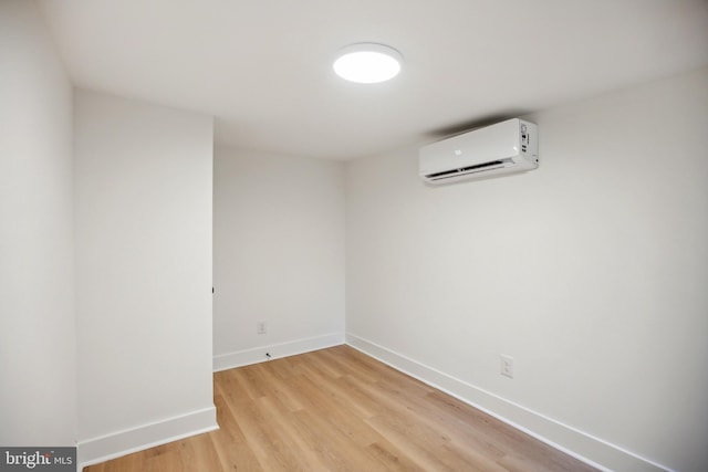 spare room with light wood-type flooring and a wall mounted AC